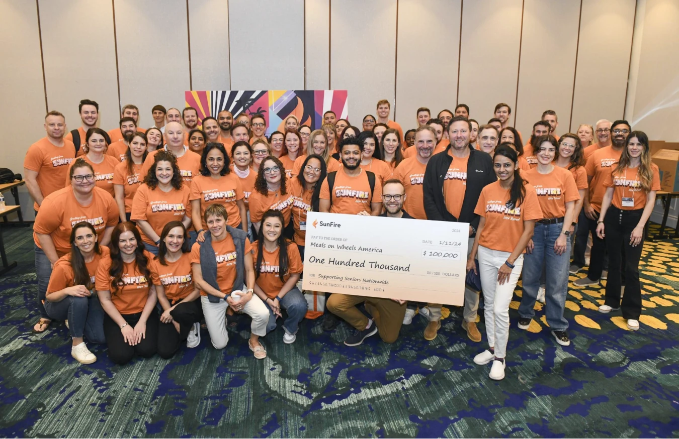 Photograph of SunFire employees holding a donation check during a 2024 company retreat