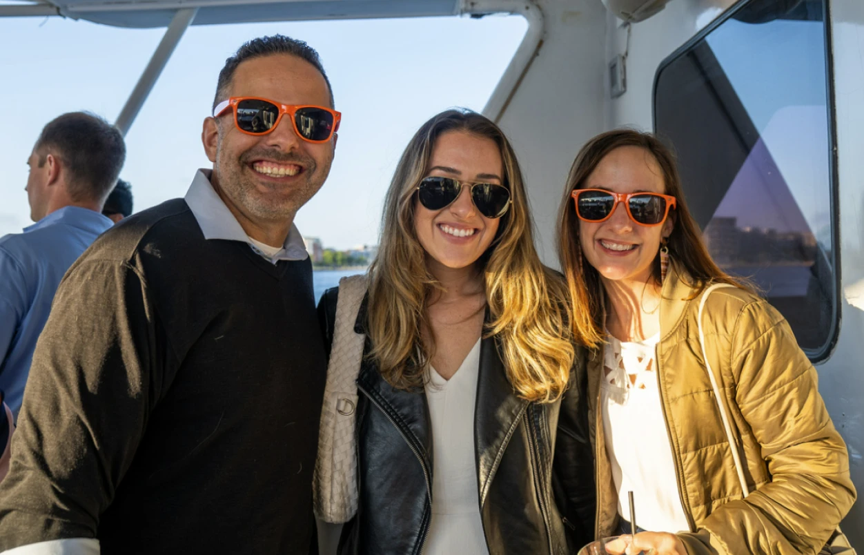 Three SunFire employees smiling with sunglasses pose for a photograph