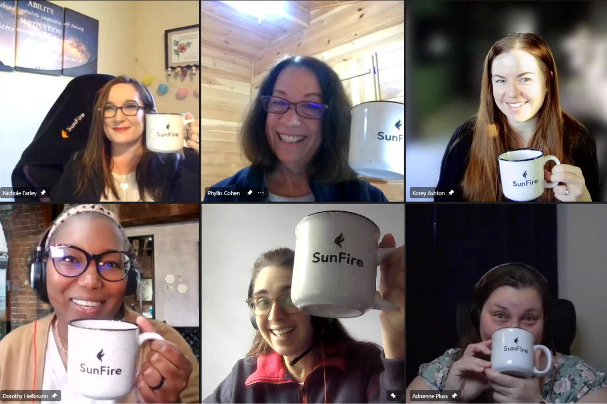 SunFire employees hold up their coffee mugs during a team meeting